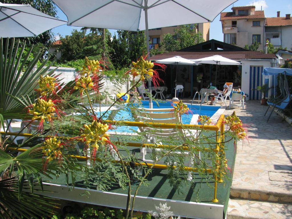 a pool with a table with flowers and umbrellas at Villa Sens in Chernomorets