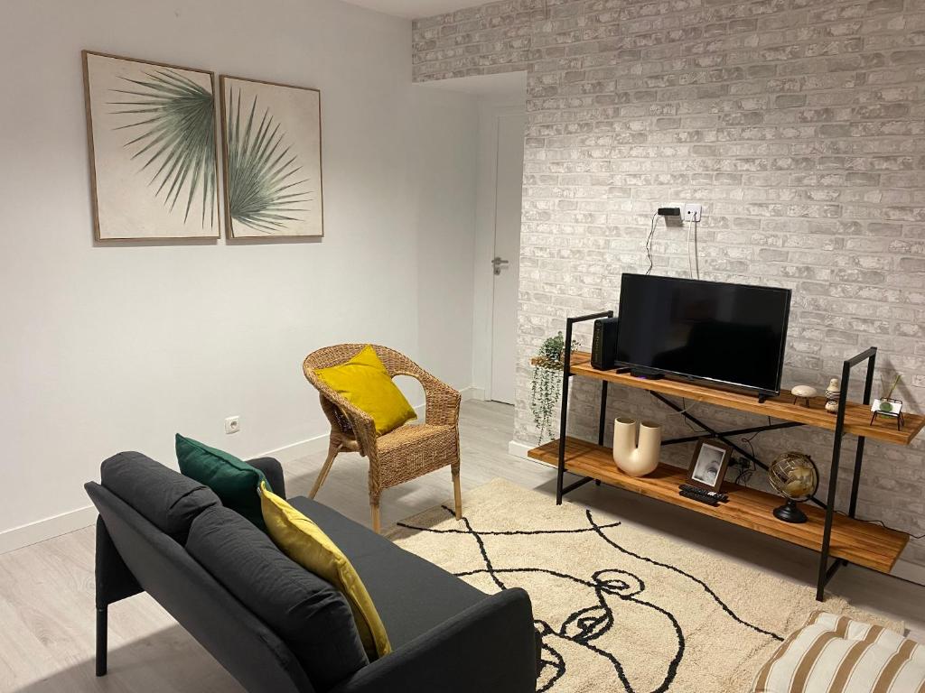 a living room with a couch and a tv at 5 Senses Hostel in Setúbal