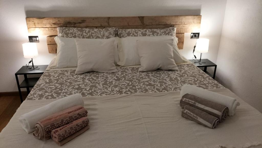 uma grande cama branca com duas almofadas em Affittacamere Armanino em Gênova