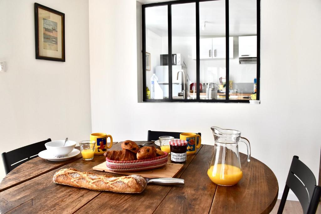 una mesa de madera con pan y zumo de naranja. en Le Chill Loft en Miramont-de-Guyenne