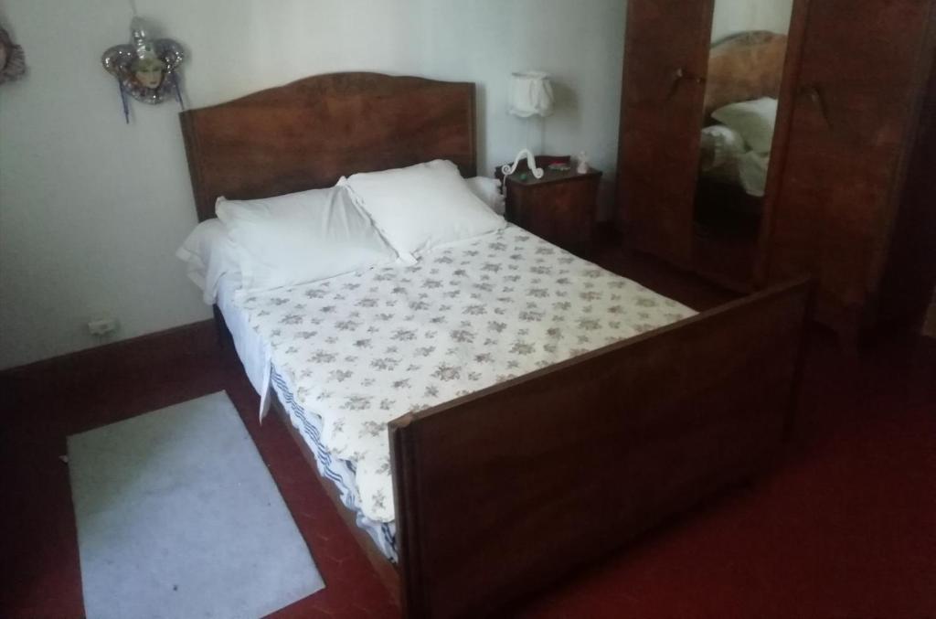 a bedroom with a bed with a wooden headboard and a mirror at Chez Fleur in Avignon