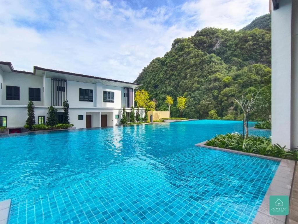 a swimming pool in front of a house with a mountain at Ipoh Sunway Villa , Guesthouse and Suites at Tambun, 6-14pax 2parking by IWH in Ipoh