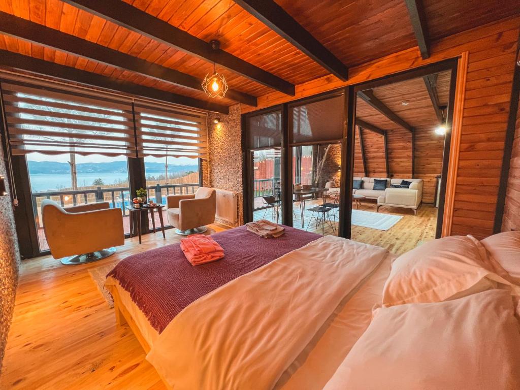 a bedroom with a large bed and a balcony at Wonder of nature bungalov sapanca in Sapanca