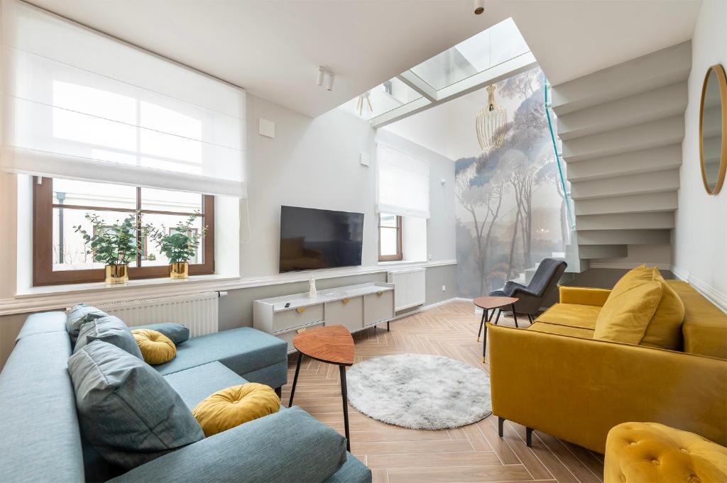 a living room with two blue couches and a tv at Unique&Luxury Penthouse With Tarrace&Parking in Łódź