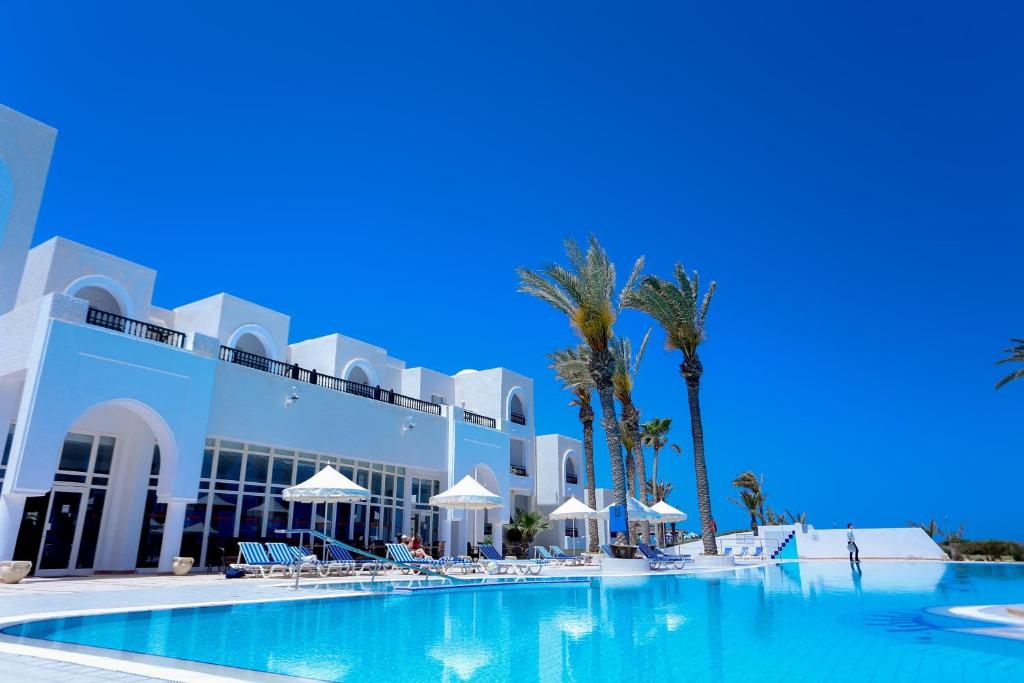 un hotel con piscina frente a un edificio en Al Jazira Beach & Spa- All Inclusive - Families and Couples Only en Houmt El Souk