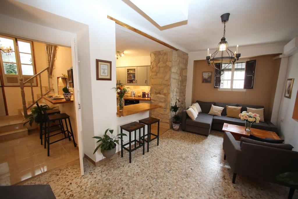 sala de estar con sofá y mesa en Casa de las Campanans, en Iznájar