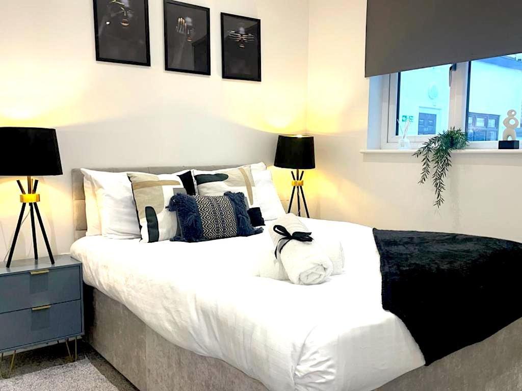a bedroom with a large white bed with pillows at 2 bed Penthouse in Liverpool City Centre in Liverpool