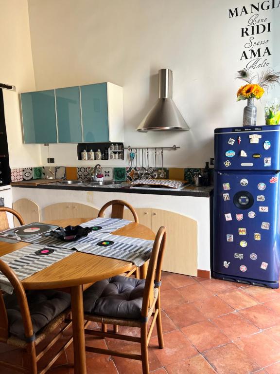 eine Küche mit einem Holztisch und einem blauen Kühlschrank in der Unterkunft The Music House in Salerno