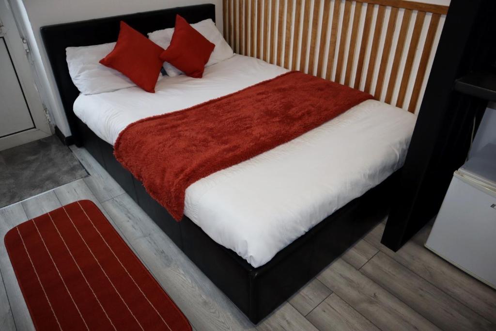 259A Queen Ediths Way في Cherry Hinton: غرفة نوم بسرير ومخدات حمراء