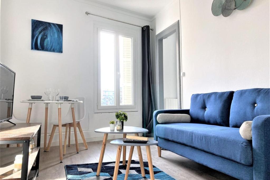un salon avec un canapé bleu et des tables dans l'établissement Le Colvert-Charmant appart proche centre et gare, au Havre