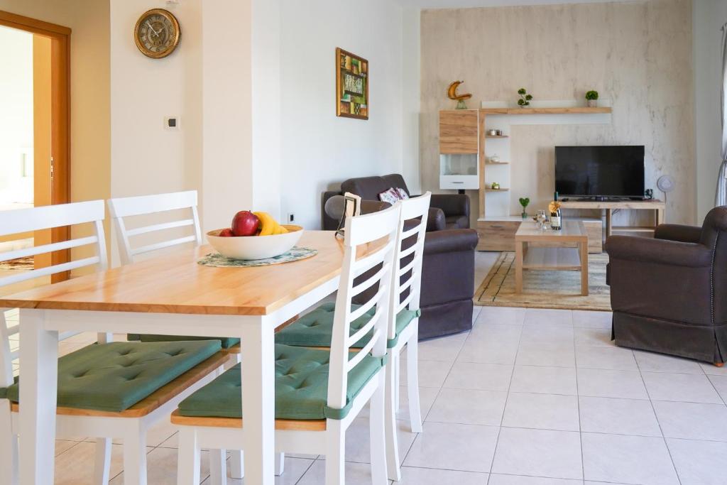 una sala da pranzo e un soggiorno con tavolo e sedie. di Kyriakos Apartment a Mastichárion
