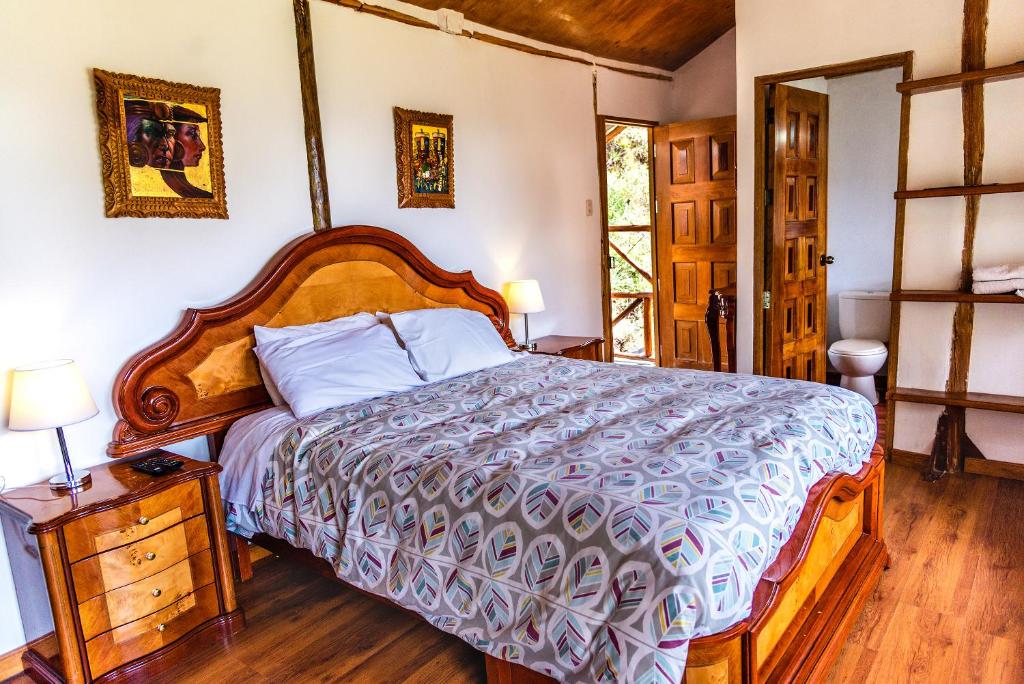 1 dormitorio con 1 cama grande y cabecero de madera en Altar Inca Hotel Mirador, en Cusco
