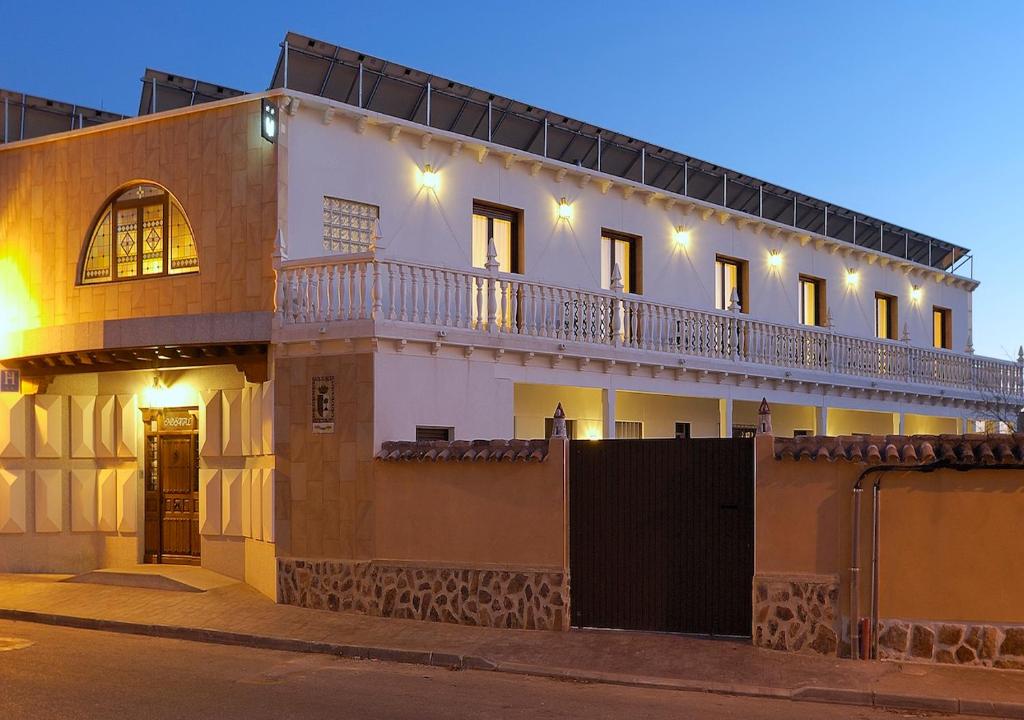 a large white building with a balcony on a street at Hostal Rural El Tejar in Layos