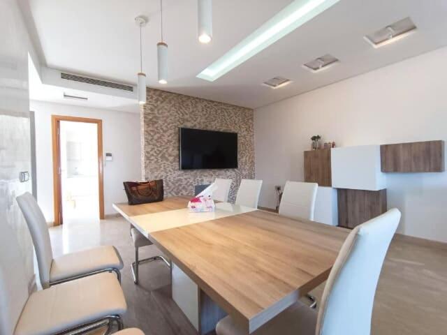 une salle à manger avec une grande table et des chaises en bois dans l'établissement Appartement Lux Safi, à Safi