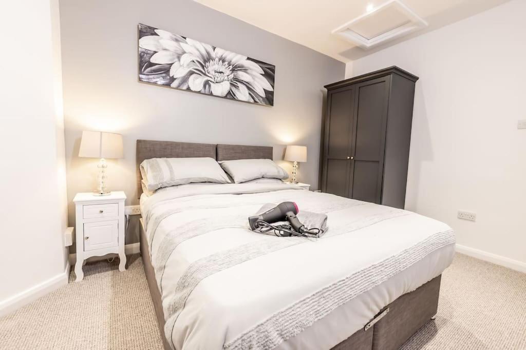 sypialnia z dużym łóżkiem i czarną szafką w obiekcie EXECUTIVE APARTMENTS free on-site parking, 2 en-suites, sleeps 4, w mieście Swindon