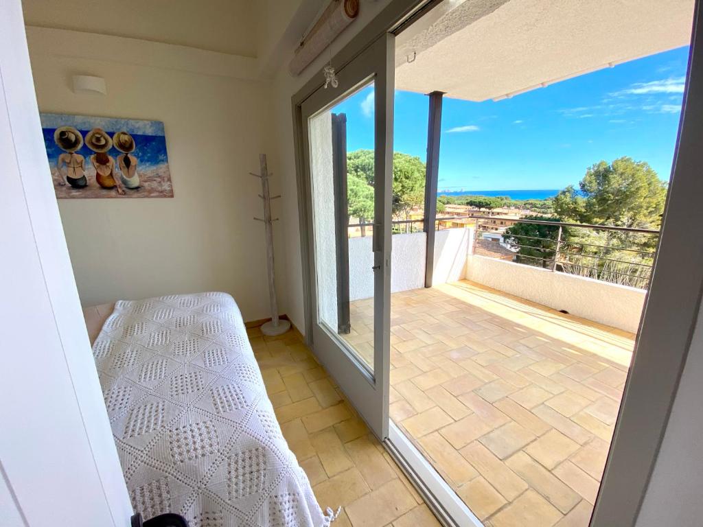 Zimmer mit Blick auf einen Balkon und einem Bett in der Unterkunft Apartamentos Lu, Playa de Pals in Pals