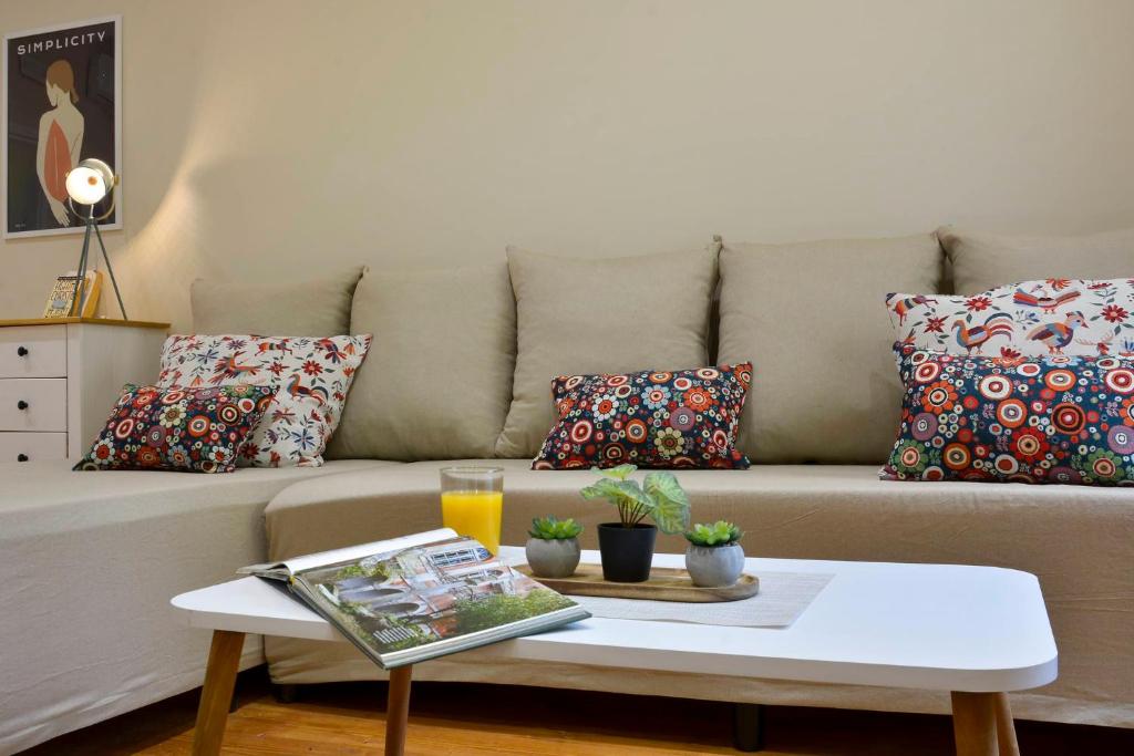 uma sala de estar com um sofá com almofadas e uma mesa de centro em Beau Maison em Corfu Town