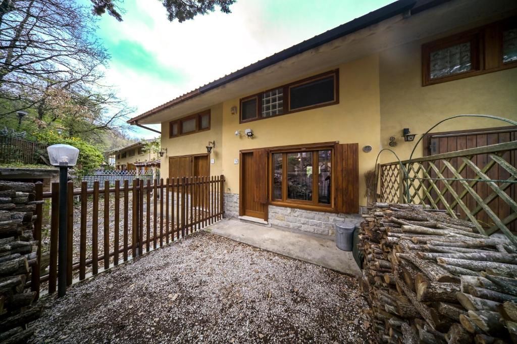 una casa con una valla y una puerta de madera en Profumo di Bosco en Spoleto