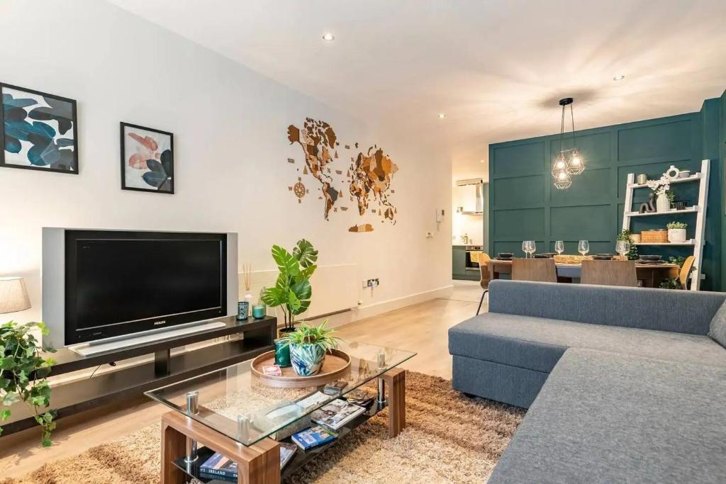 a living room with a blue couch and a tv at Cosy and modern apartment in the heart of Dublin in Dublin