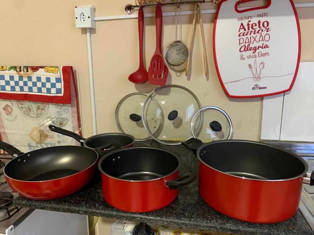 three pots and pans on a counter in a kitchen at Divino Espírito Santo in Aparecida