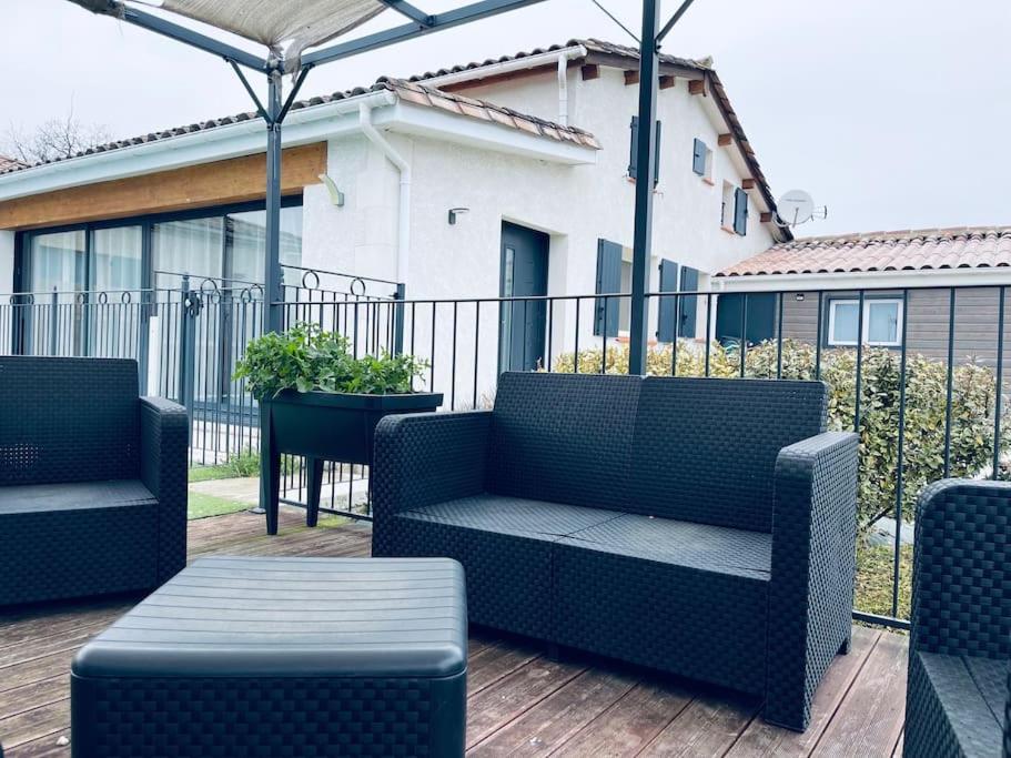 un patio con 2 sillas y una mesa en una terraza en Jolie Maison de vacance confort, en Boudy