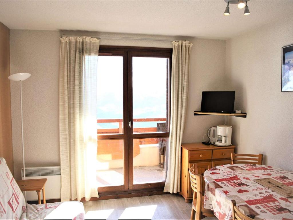 a bedroom with a bed and a sliding glass door with a balcony at Appartement Auris, 1 pièce, 4 personnes - FR-1-297-58 in Auris