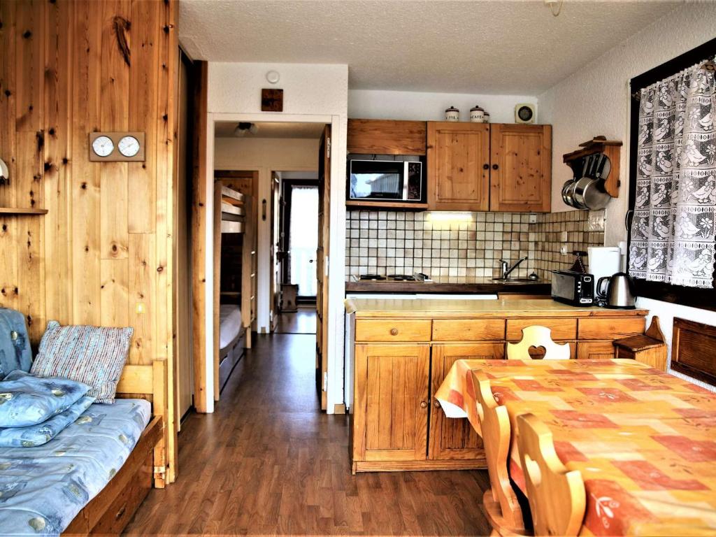 een keuken met houten kasten en een tafel in een kamer bij Appartement Auris, 2 pièces, 6 personnes - FR-1-297-26 in Auris