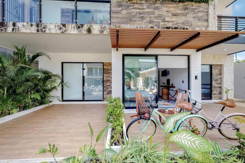 a house with two bikes parked on a patio at Spacious Condo, beautiful pool, Wi-Fi - Casa Kaanal 104 in Tulum