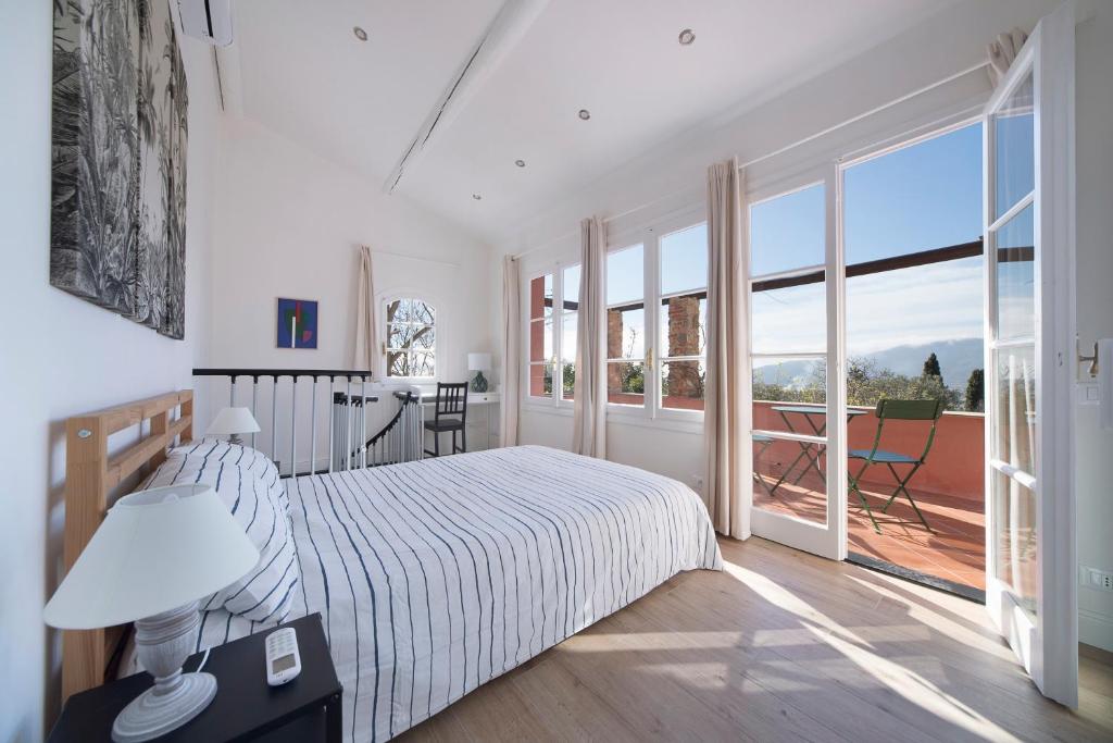 - une chambre blanche avec un lit et un balcon dans l'établissement Incantevole Veranda Panoramica, à Albenga