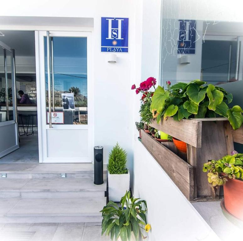 uma porta da frente de uma loja com plantas e flores em HOSTAL CASA EMILIO em Almería