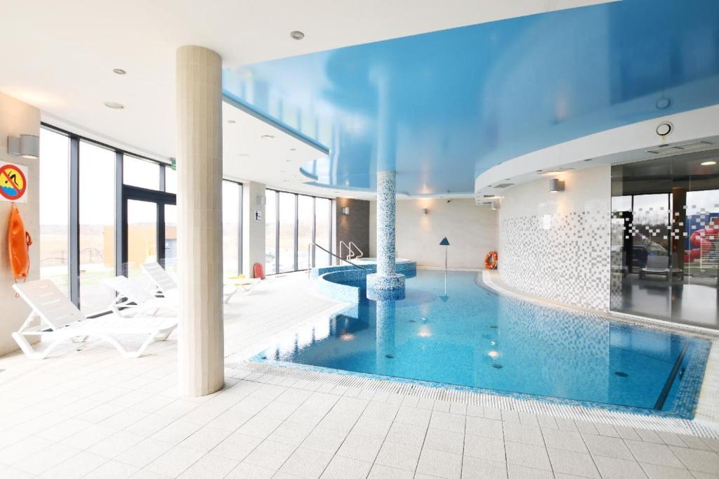 una grande piscina in un edificio con piscina di Baltic Plaza Resort a Kołobrzeg