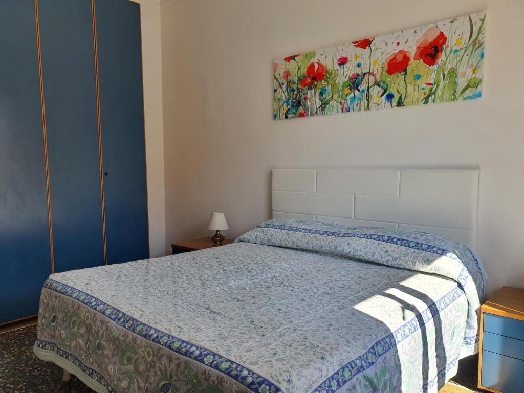 ein Schlafzimmer mit einem Bett und einem Gemälde an der Wand in der Unterkunft Rapallina in Rapallo