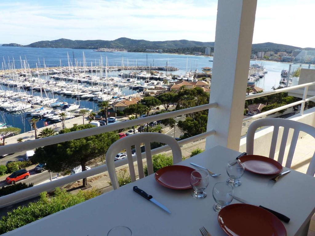 un tavolo con bicchieri da vino su un balcone con porto turistico di Appartement Le Lavandou, 3 pièces, 4 personnes - FR-1-308-49 a Le Lavandou