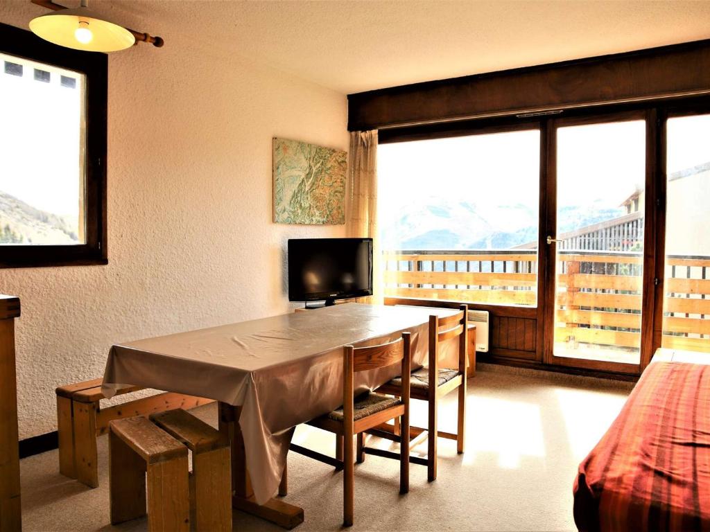 Una habitación con una mesa de comedor con vistas. en Auris en Oisans - Appartement 3 pièces cabine - 6 couchages au pied des pistes - FR-1-297-77, en Auris