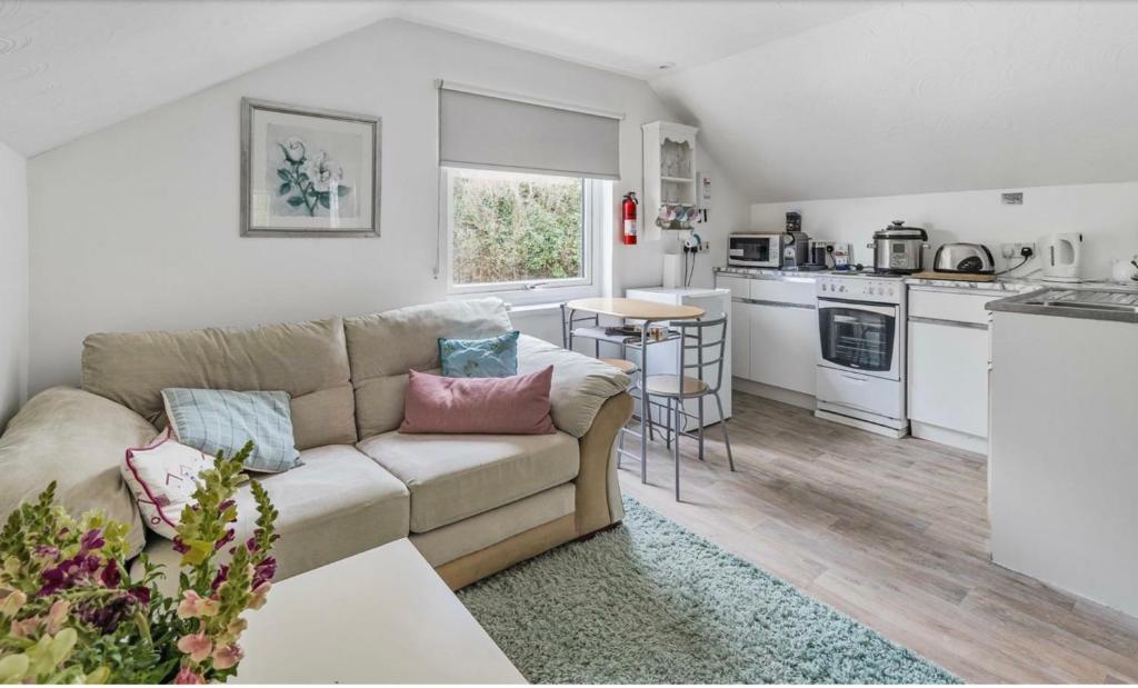 a living room with a couch and a kitchen at Hardwick Flat in Barnstaple