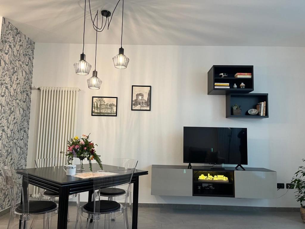 uma sala de estar com uma mesa e uma televisão em Domus Silvana Apartments em Ravenna