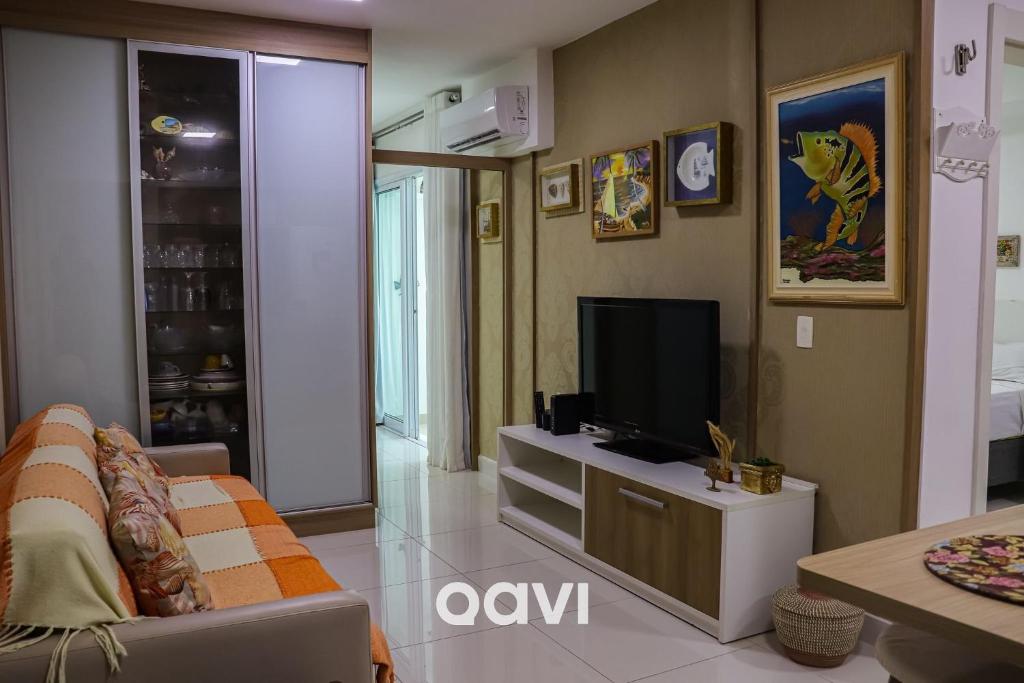 a living room with a couch and a television at Qavi - Flat em Resort Beira Mar Cotovelo #InMare57 in Parnamirim