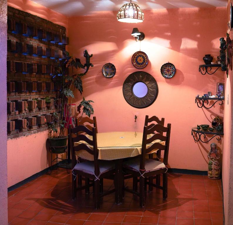 uma sala de jantar com uma mesa e cadeiras e pratos na parede em CASA JOAQUÍN HOSTAL em Oaxaca de Juárez