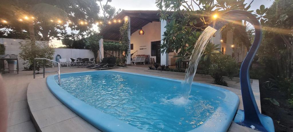 a swimming pool with a fountain in a yard at Casa Paraiso de Sonho Verde in Paripueira