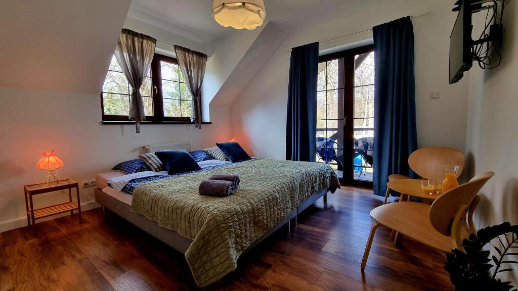 Schlafzimmer mit einem Bett, einem Tisch und Fenstern in der Unterkunft Pokoje Gościnne Słotwińscy in Wetlina