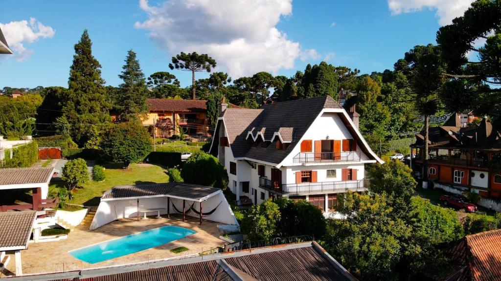カンポス・ド・ジョルドンにあるCasa Três Rios - Campos do Jordãoのスイミングプール付きの家屋の空中ビュー