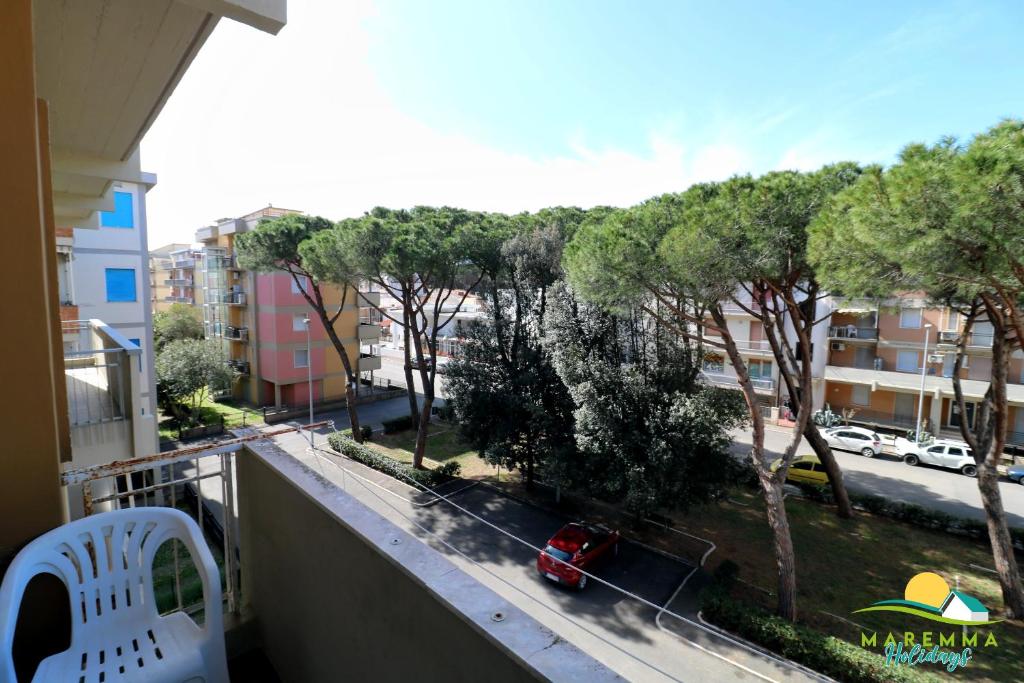 balcón con vistas a la calle y a los árboles en Maremma Holidays : Trasimeno Apartment, en Follonica