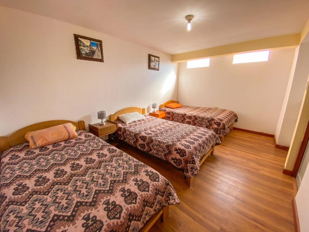 a room with two beds in a room at Sueños Sambleños in Cusco