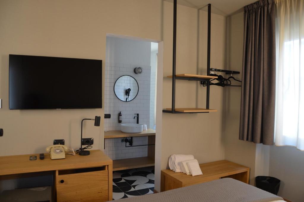 a hotel room with a tv on the wall at RE Versiliana Junior-House in Marina di Pietrasanta