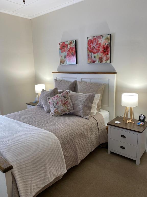 a bedroom with a bed with two lamps on it at Hideaway on Hume in Boonah