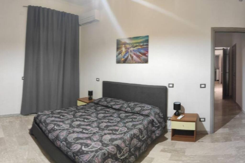 ein Schlafzimmer mit einem Bett und einem Bild an der Wand in der Unterkunft Casa Alea - Appartamento turistico - Paola- in Paola