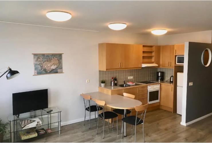 uma cozinha com mesa e cadeiras num quarto em Laugarvatn Apartment em Laugarvatn