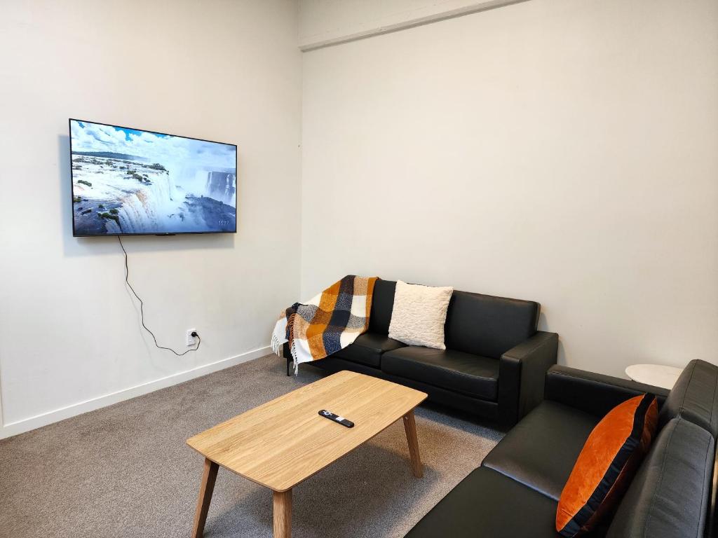 uma sala de estar com um sofá e uma mesa de centro em U Suites on Webb em Wellington