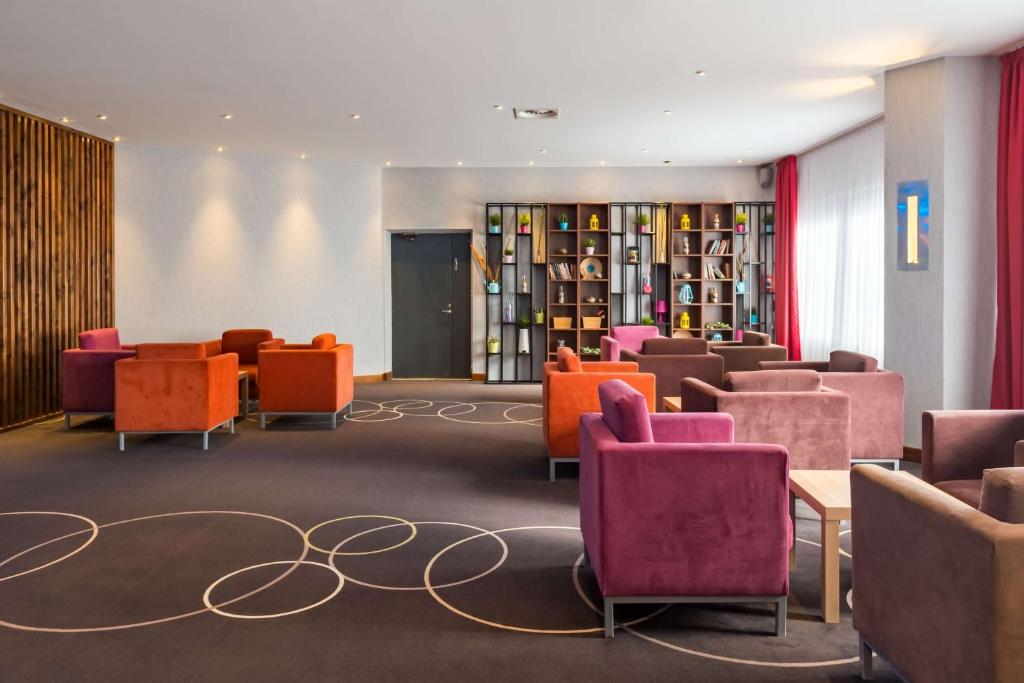 a waiting room with colorful chairs and bookshelves at Park Inn by Radisson Pulkovskaya Hotel & Conference Centre St Petersburg in Saint Petersburg