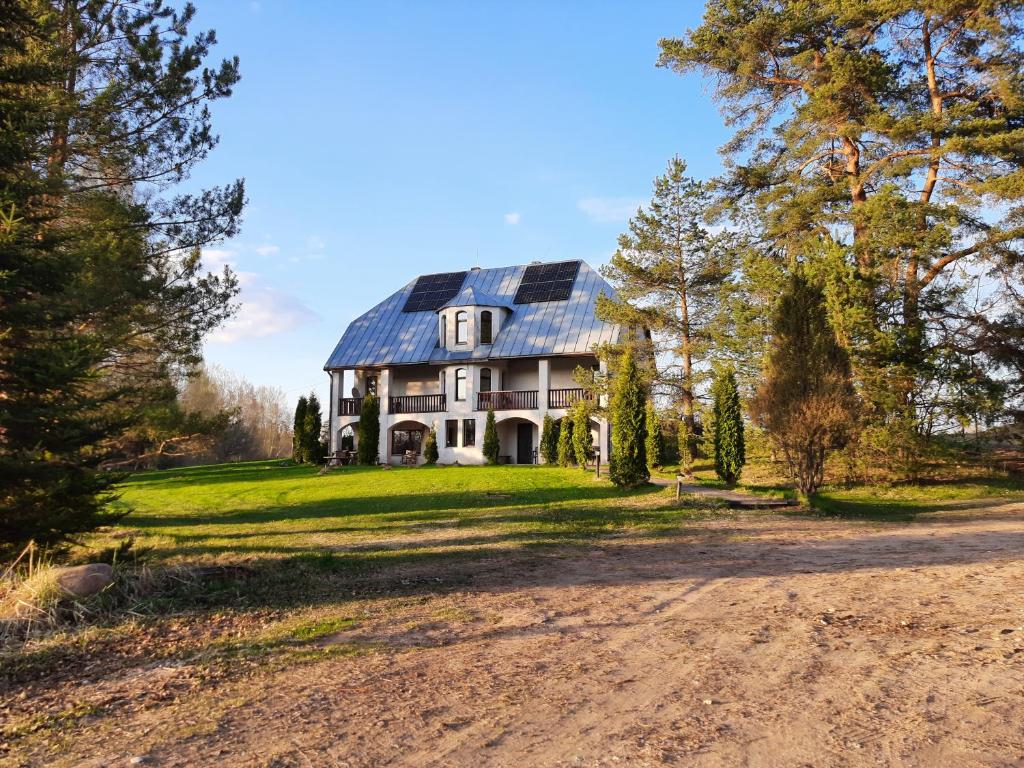 a house with a solar roof on a dirt road at Ezernieki in Valka